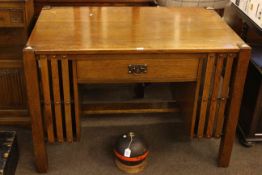 Arts & Crafts oak desk having central drawer flanked by open ends, 76.5cm by 111cm by 71cm.