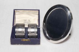 Small oval silver photograph frame and pair of cased silver napkin rings.