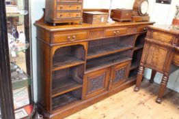 Late Victorian mahogany cabinet bookcase having three drawers above open shelves and two carved