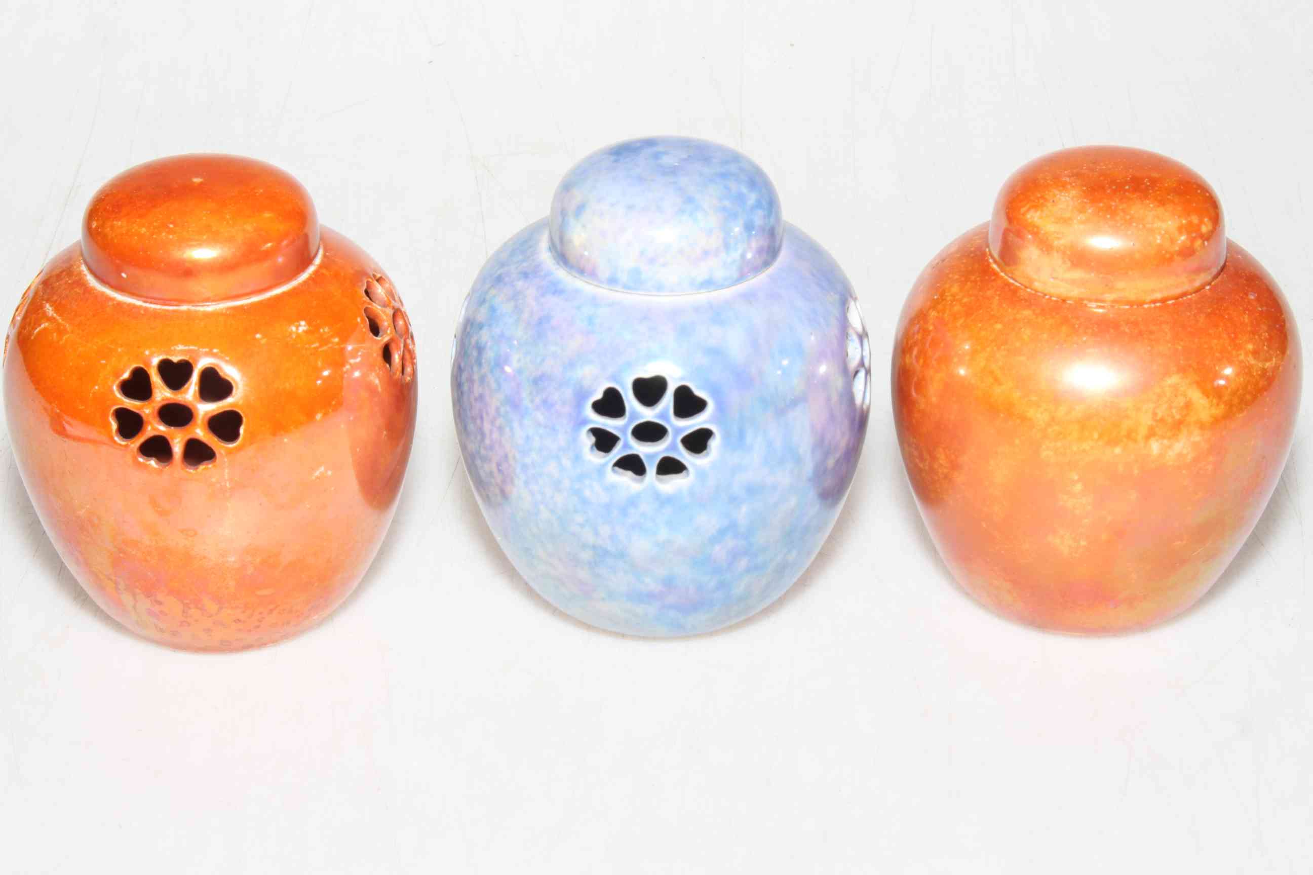 Three Ruskin Pottery pot pourri jars and lids, two orange glazed and blue one blue glazed,