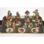 Collection of fourteen Hummel figures and three small plates.