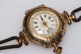 Ornate 14 carat gold ladies wristwatch with leather strap,