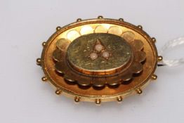 Victorian die-stamped gold brooch with three seed pearls, tests as 15 carat gold.