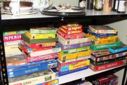 Large collection of vintage and modern jigsaw puzzles.