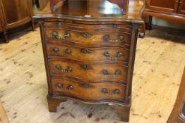 Walnut and mahogany serpentine front bachelors chest having brush slide above four graduated