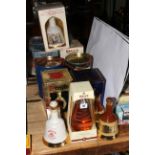 Twelve whisky decanters including Bell's Dimple.