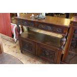 Carved oak buffet having two lion mask drawers above an open compartment with two cupboard doors