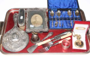 Silver backed brush and mirror, silver photograph frame, silver plated spoons, forks and knife,