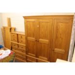 Pine five piece bedroom suite comprising triple door combination wardrobe, five drawer chest,