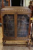 1920's/30's carved oak two door bookcase, 133cm by 86cm by 27cm.