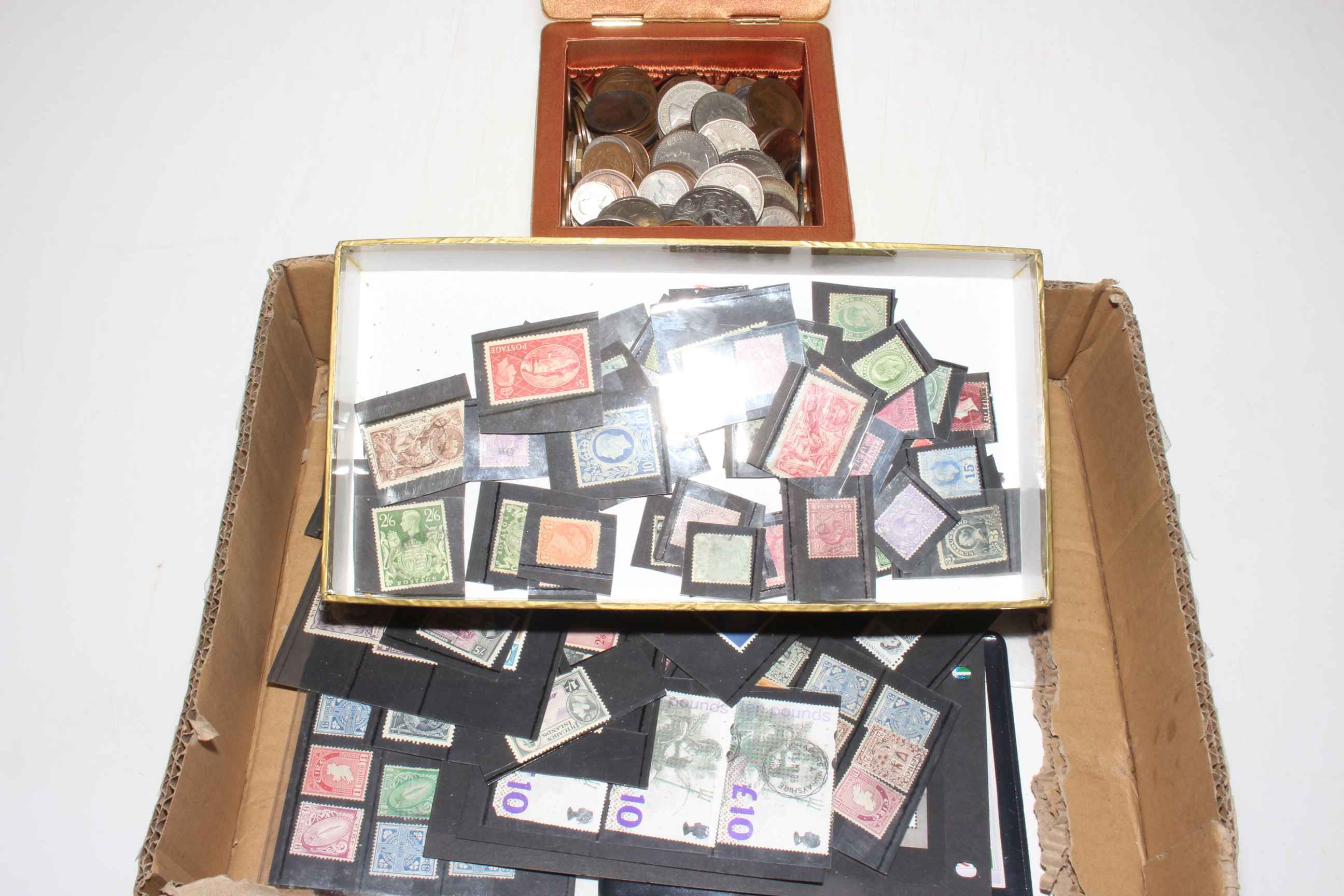 Collection of assorted coins and Commonwealth stamps.