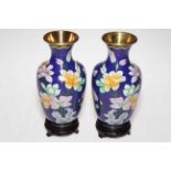 Pair of Cloisonne floral decorated vases on wooden stands, 23cm.