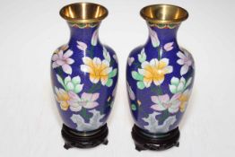 Pair of Cloisonne floral decorated vases on wooden stands, 23cm.