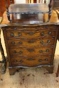 Walnut and mahogany serpentine front bachelors chest having brush slide above four graduated