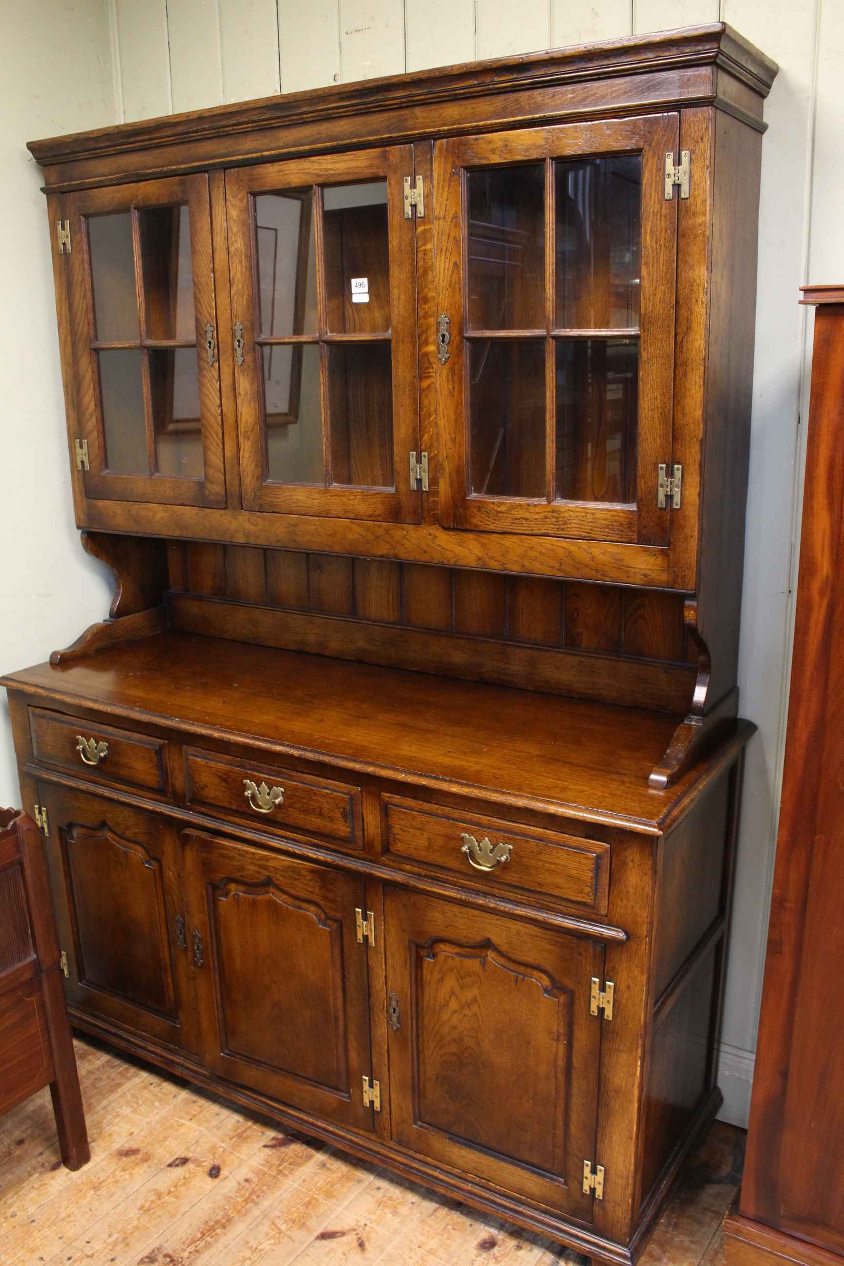 Oak dresser having three glazed panel cupboard doors above a base of three drawers with three