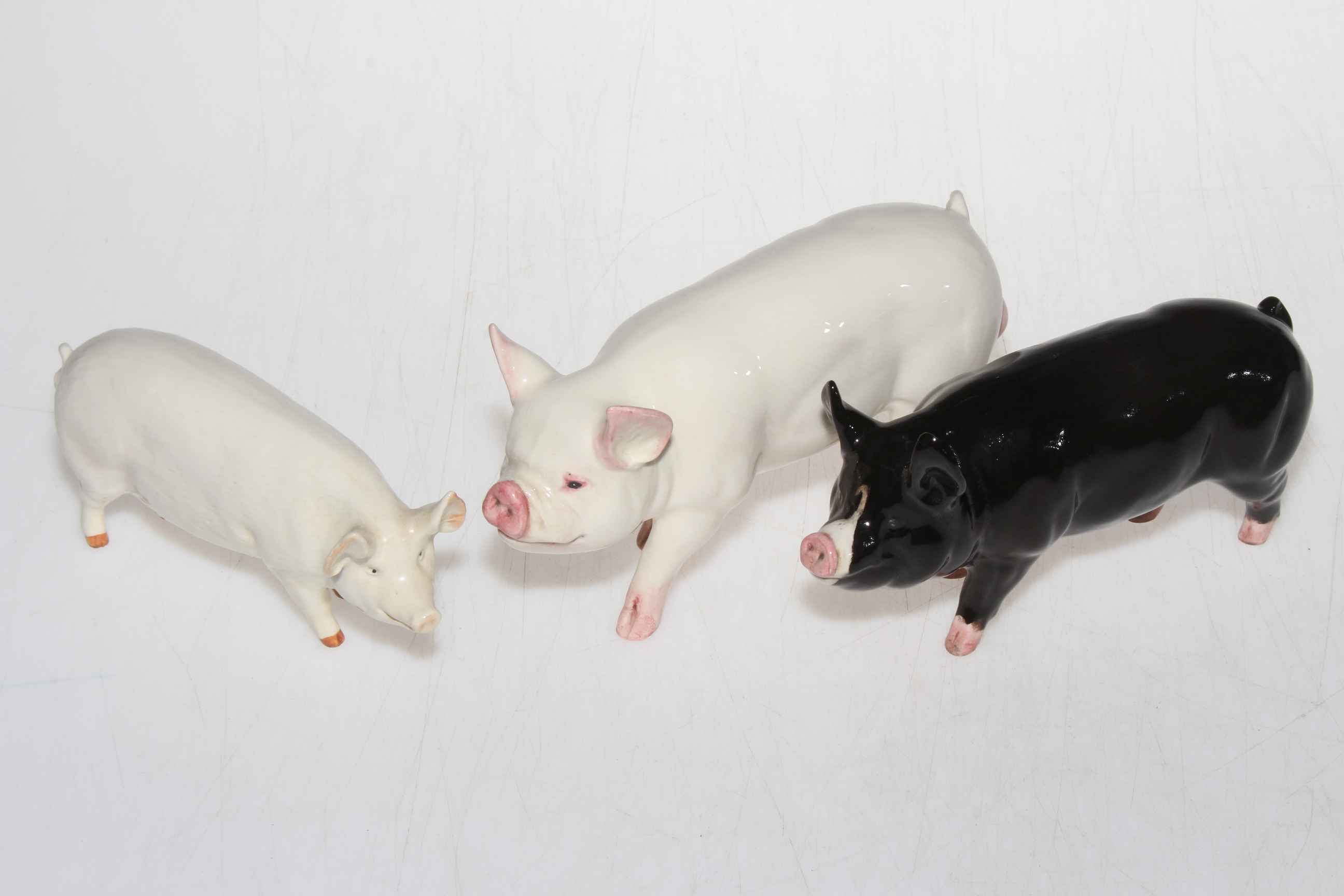 Three Beswick pig figurines.