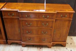 Yew breakfront side cabinet having four central drawers flanked by smaller drawers with cupboard