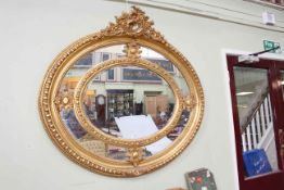 Large ornate gilt framed bevelled wall mirror with floral and swag crest,