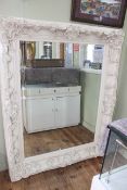 Large white painted ornate framed bevelled wall mirror, 156cm by 126cm including frame.