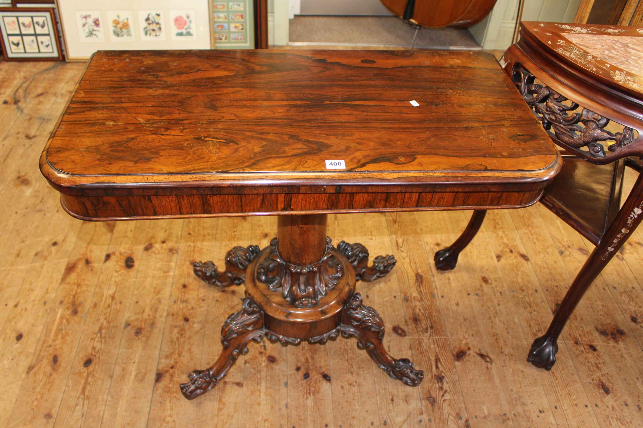 Victorian rosewood fold top tea table on turned pedestal to four carved scrolled legs,