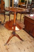 Mahogany circular dished top two tier dumb waiter on carved pedestal triform base, 101cm.