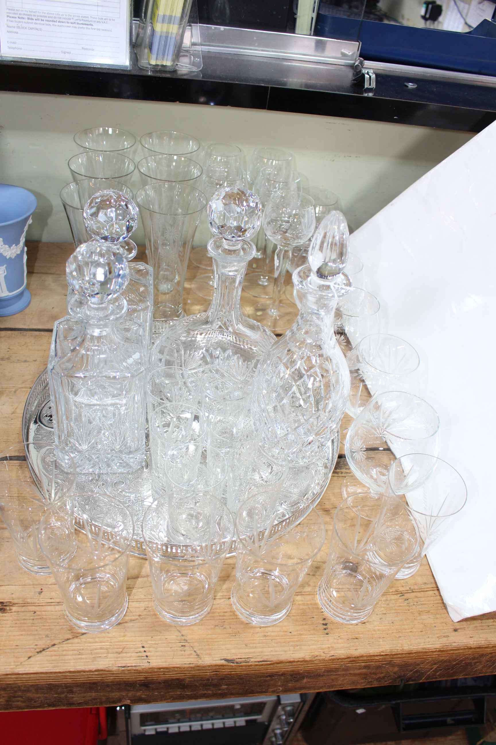 A suite of 30 etched and cut glasses, four decanters and a silver plated tray.