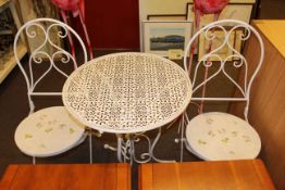 Wrought metal circular patio table and two folding chairs.