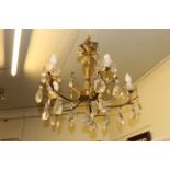 Ornate gilt metal five branch ceiling light with glass lustre drops.