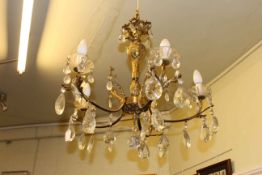 Ornate gilt metal five branch ceiling light with glass lustre drops.