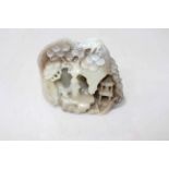 Chinese carved mineral boulder with figure and animal in outdoor scene framed with blossom trees,