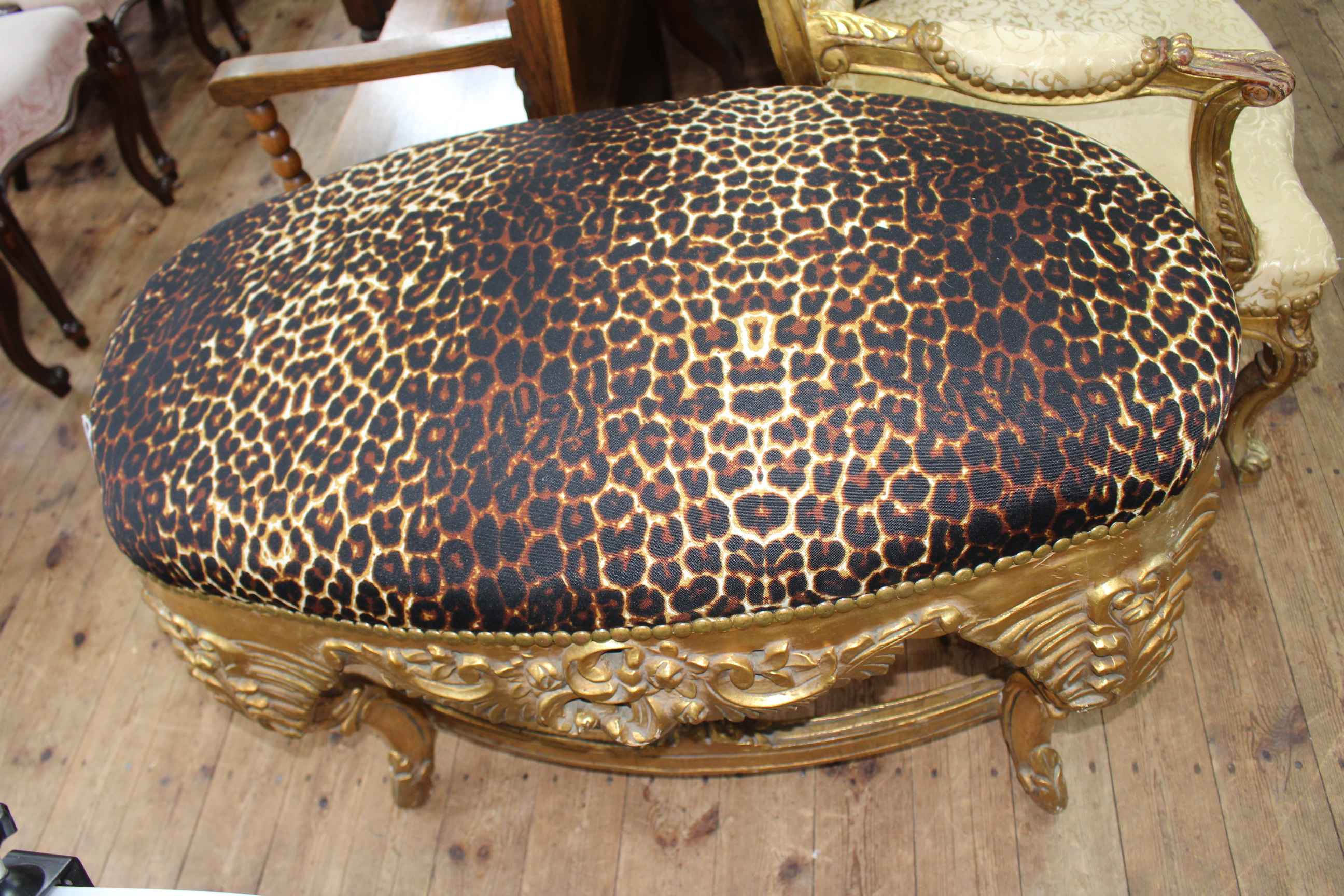 Large gilt framed oval stool in leopard skin print fabric.