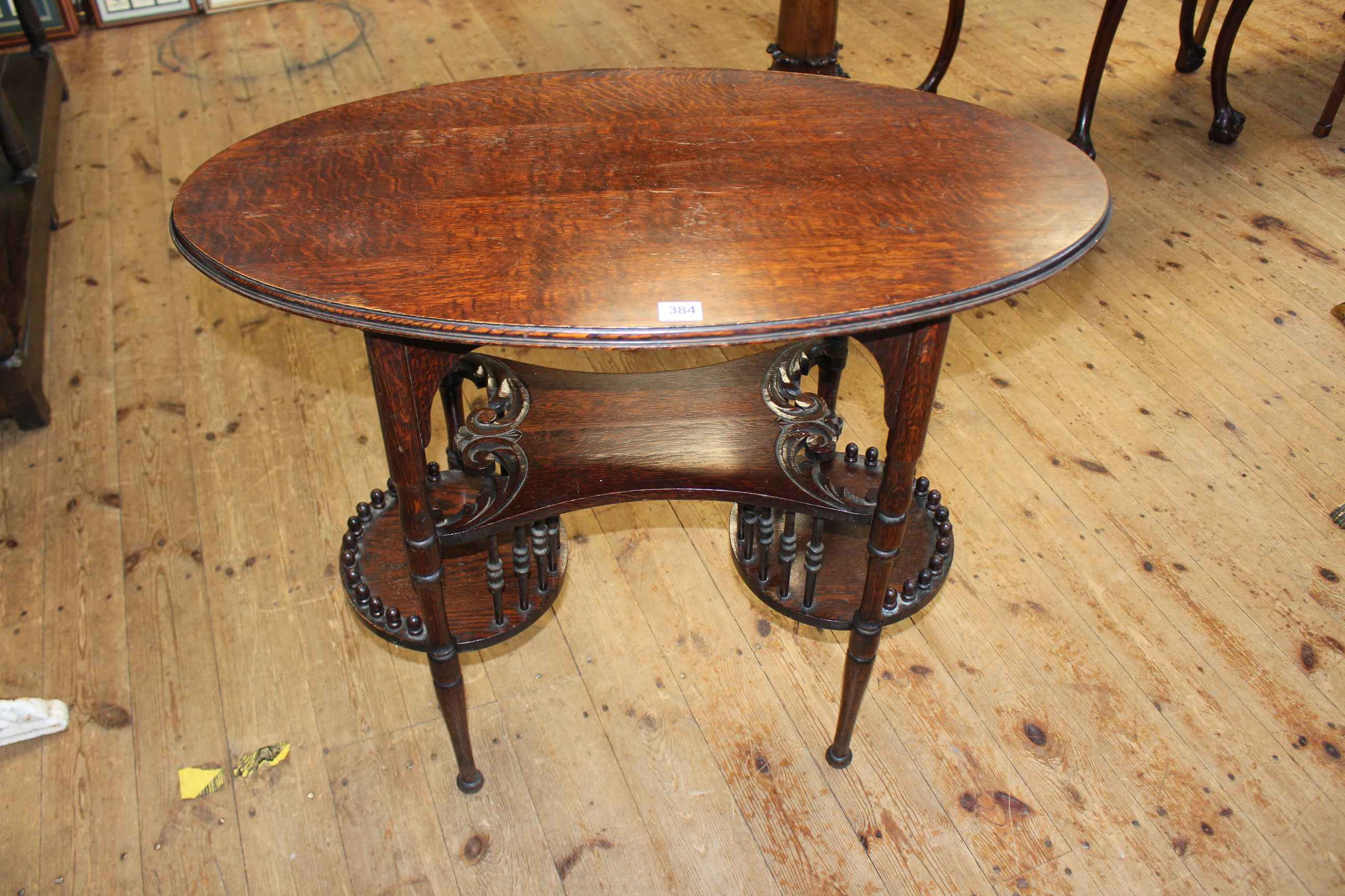Unusual oval oak occasional table with two tiered undershelf, 74cm by 84cm by 46cm.