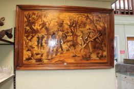 Large marquetry framed wall panel depicting three elephant in jungle landscape, 103cm by 163cm.