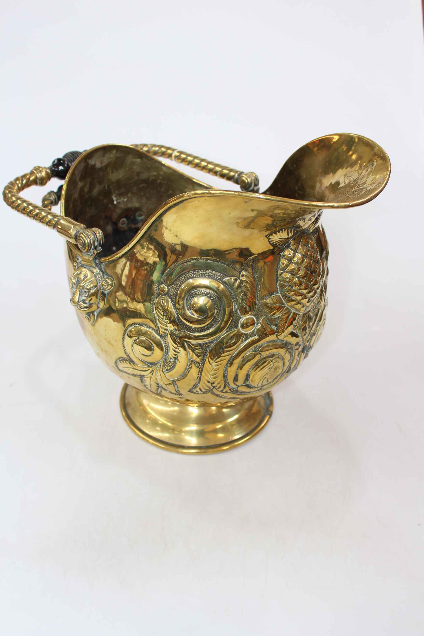Late Victorian embossed brass coal helmet with ebony handles.