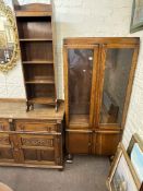 Oak glazed door cabinet bookcase, slim oak open bookcase and carved oak two door sideboard (3).