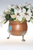 Ornate copper and brass three foot planter with lion handle decoration, 34cm high.