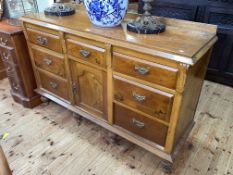 Victorian pine dresser having central drawer above a cupboard door flanked by six drawers on six
