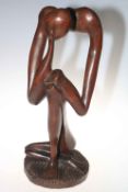 An abstract wood carving of The Thinker, 61cm high.