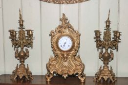 An ornate gilt metal three piece clock garniture.