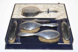 Cased silver six piece brush set with lightly embossed scroll border, Chester 1921/22.