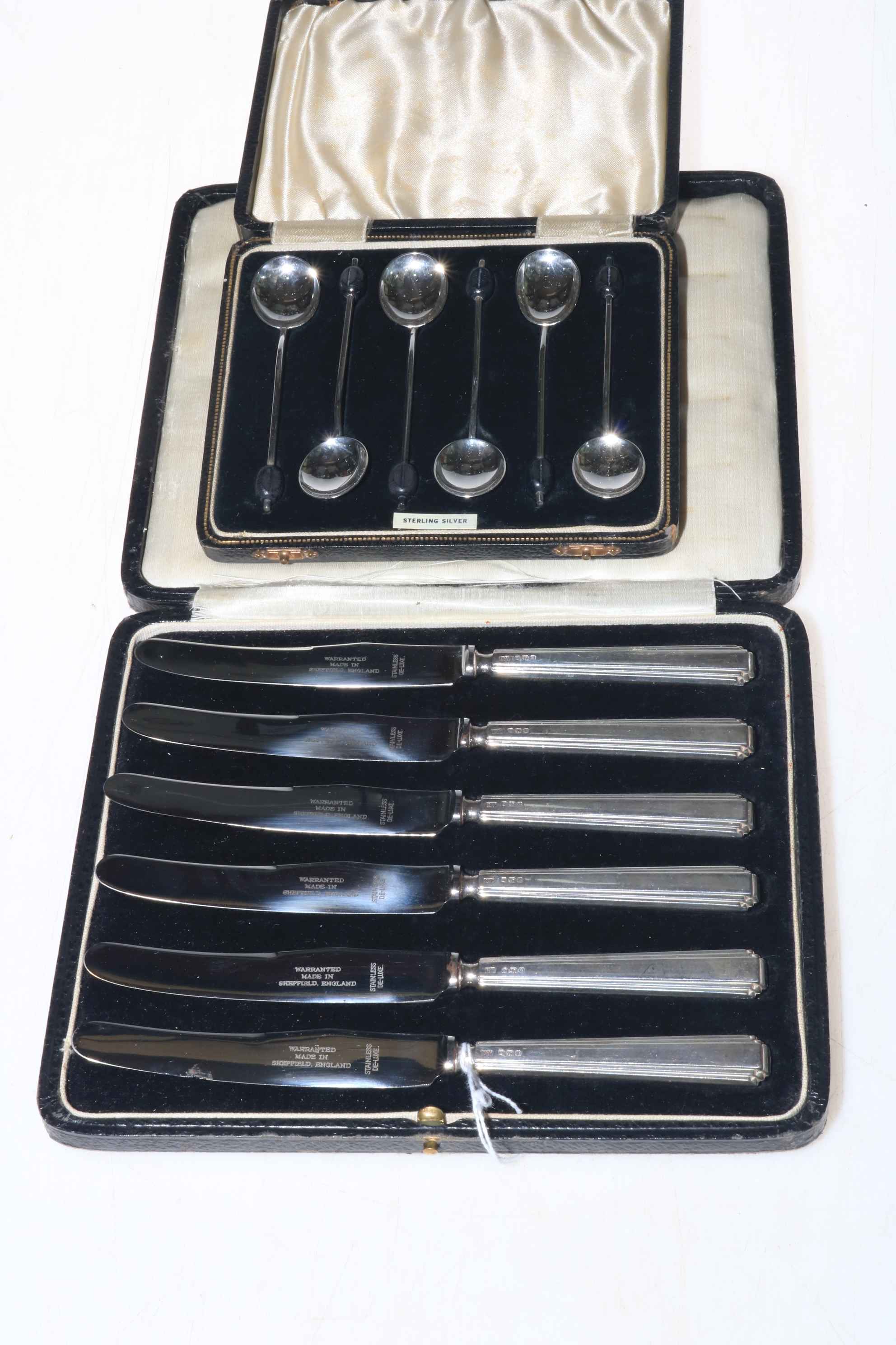 Case of silver handled knives and case of silver spoons (2).
