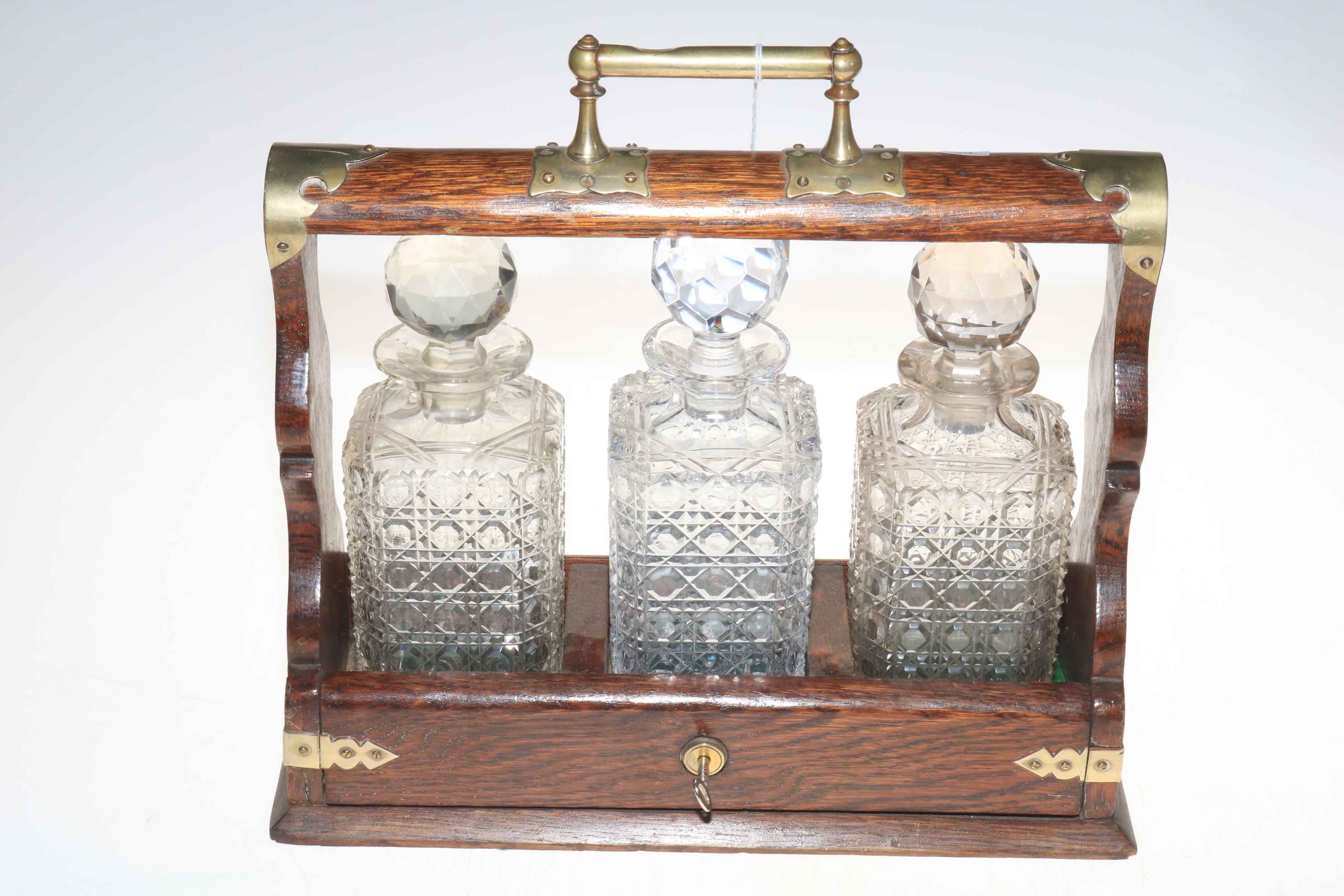 Oak tantalus with three matched crystal decanters.