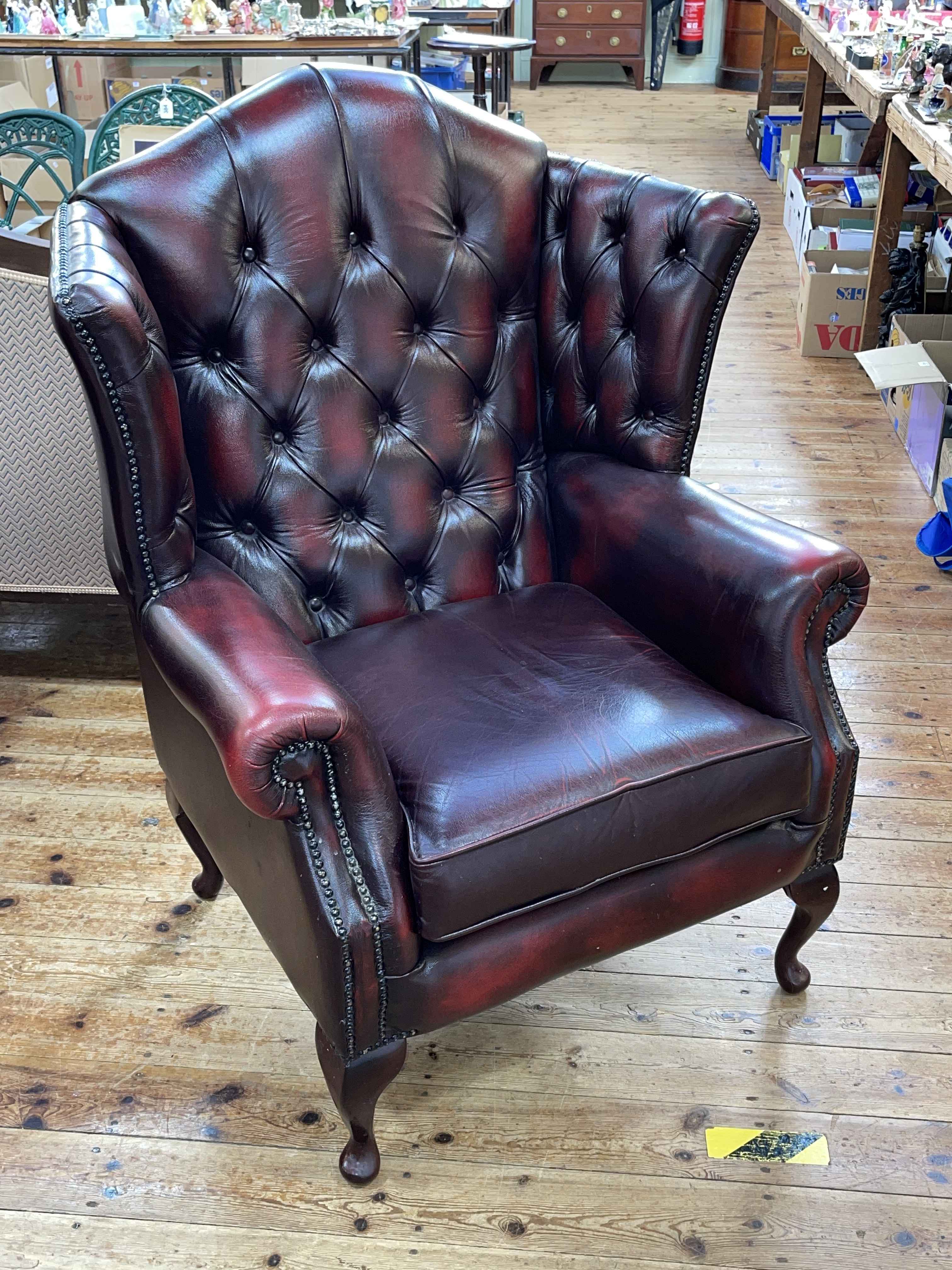 Thomas Lloyd ox blood buttoned leather wing armchair.