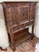 Carved oak and linen fold panelled side cabinet having central door above two drawers with