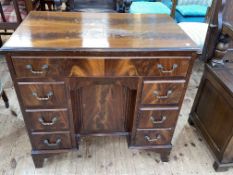 Mahogany seven drawer kneehole desk with inset cupboard door, 75cm by 78.5cm by 48cm.