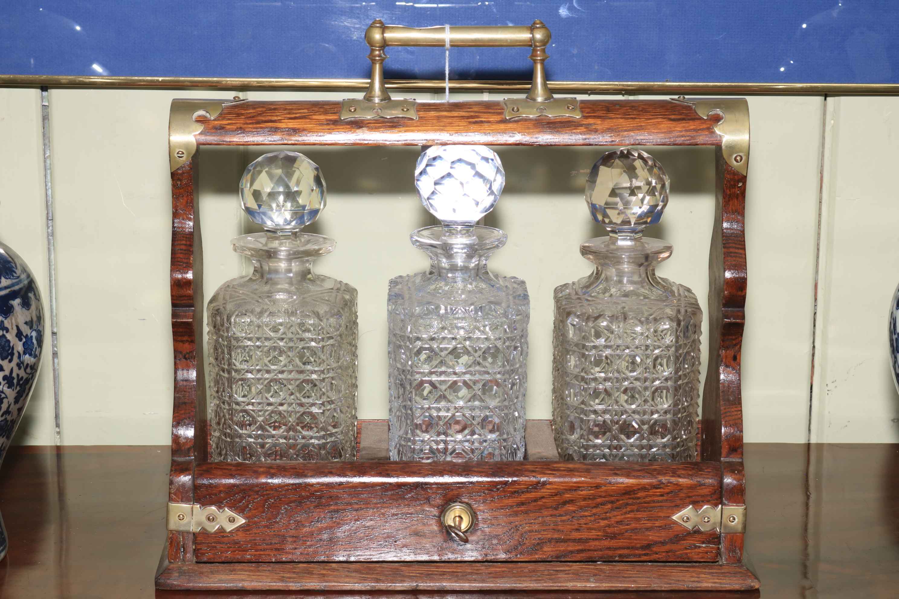 Oak tantalus with three matched crystal decanters.