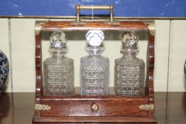 Oak tantalus with three matched crystal decanters.