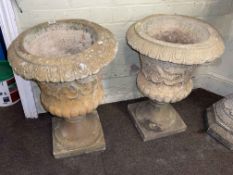 Pair of weathered pedestal style garden urns.