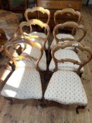 Set of six Victorian walnut dining chairs raised on cabriole legs.
