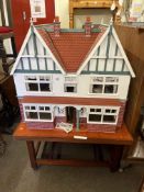 Large Elizabethan style dolls house with electric on portable stand.